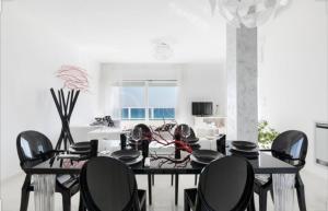 a dining room with a black table and chairs at Attico Diamante in Gallipoli