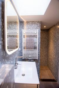 een badkamer met een witte wastafel en een raam bij Studio Sunrise in Zandvoort