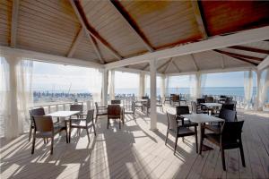 un ristorante con tavoli e sedie e vista sull'oceano di VOI Floriana Resort a Simeri Mare