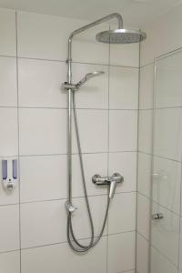 a shower with a shower head in a bathroom at Hotel Restaurant Rodizio Paderborn in Altenbeken