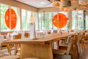 een lange houten tafel in een kamer met stoelen bij Droste's Herberg in Tubbergen