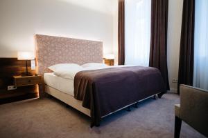 a bedroom with a large bed with a purple blanket at Zum Mühlenteich in Bassum