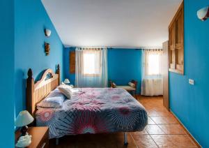 サン・マルティン・デ・トレベホにあるCasa Rural Las 6 Hermanasの青い壁のベッドルーム1室、ベッド1台が備わります。