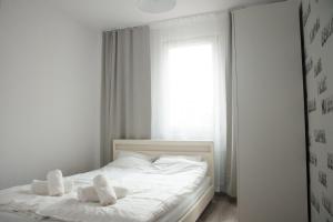 una camera da letto con un letto bianco e asciugamani di Apartament Karolewska a Łódź