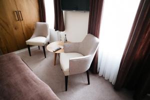 Zimmer mit 2 Stühlen, einem Tisch und einem Sofa in der Unterkunft Zum Mühlenteich in Bassum