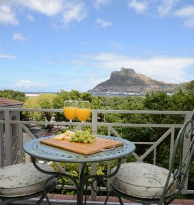 a table with two glasses of orange juice and grapes at dk villas 1 Harbour View Hout Bay in Hout Bay