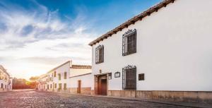 - un bâtiment blanc dans une rue pavée dans l'établissement Casa del Comendador de Almagro, à Almagro