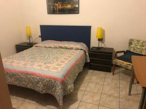 a bedroom with a bed and a chair at B&B " Guzzi - Inn " in Mandello del Lario