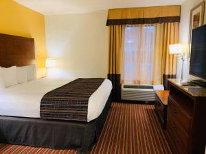 Habitación de hotel con cama y TV en Country Inn & Suites by Radisson, Alpharetta, GA en Alpharetta