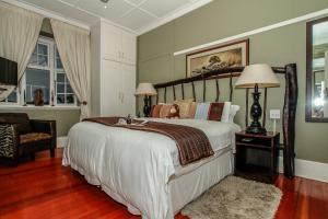 a bedroom with a large bed and a chair at Acorn B&B in Durban