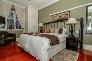 a bedroom with a large bed and a chair at Acorn B&B in Durban in Durban +59 photos