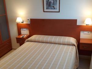 Habitación de hotel con 1 cama y 2 mesitas de noche en Hostal Forum en Villa del Río