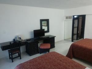 a bedroom with a dresser and a desk with a mirror at Hotel Maya Tabasco in Villahermosa