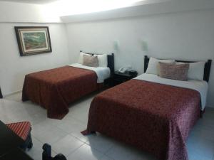a hotel room with two beds in a room at Hotel Maya Tabasco in Villahermosa
