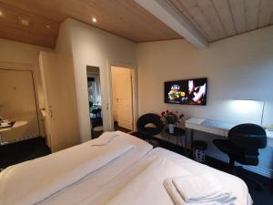 Bente's Guesthouse في هولستيبرو: غرفة نوم بسرير ومكتب مع كراسي