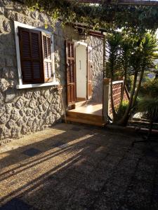 a house with a door and a tree in front of it at 1 Maison en pierre in Petreto-Bicchisano