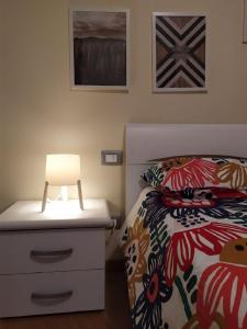Un dormitorio con una cama y una lámpara en un tocador en FORT.Montagna A106 en Rivisondoli