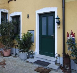 a green door of a house with potted plants at Villa Kreuthhof Appartements in Klosterneuburg