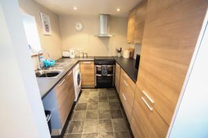 a small kitchen with wooden cabinets and a sink at Laston Mews in Ilfracombe