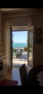 een kamer met een deur naar een balkon met uitzicht op de oceaan bij Letizia Apartment in Crotone