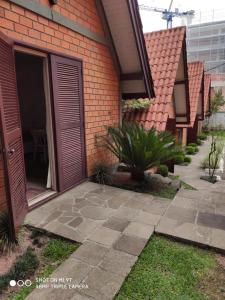 a brick house with a door and a patio at Hotel Cabana Jardim de Flores in Gramado