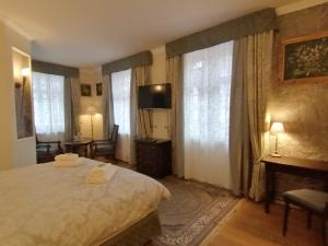 a bedroom with a bed and a television and windows at Hotel Adler in Sankt Georgen im Schwarzwald