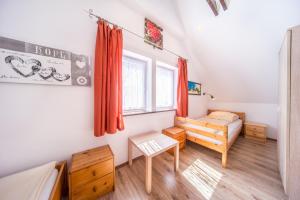 a bedroom with a bed and a couch and a table at Domki Tutti Frutti in Pobierowo
