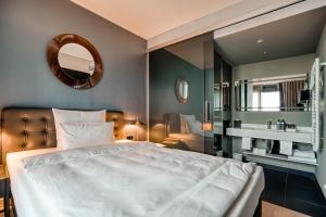 a bedroom with a large white bed and a mirror at CLOUD No7 APARTMENTS in Stuttgart