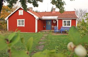 ein rotes Haus mit einer blauen Tür und einem Hof in der Unterkunft Haus Fjäril in Laxeby