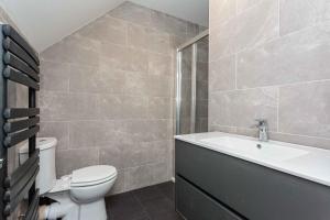a bathroom with a toilet and a sink and a bath tub at Cherry Property - Berry Apartments in Blackpool