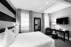 a hotel room with a white bed and a desk at Hotel Mancino 12 in Rome