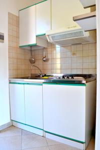 Una cocina con gabinetes azules y blancos y una estufa. en Appartamenti Le Fornaci, en Marina di Campo