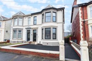 a large white house with a driveway at Cherry Property - Berry Apartments in Blackpool