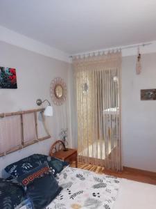 una camera da letto con un letto e una grande finestra di La maison de vos vacances a Claret