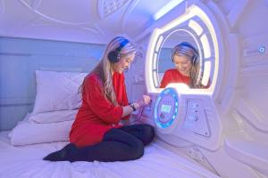 two women sitting on a bed in a room at Capsule Hostels Tallinn in Tallinn
