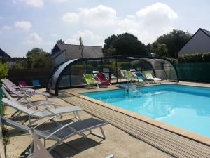 a swimming pool with lounge chairs next to a swimming poolvisor at Résidence le safran in Erdeven