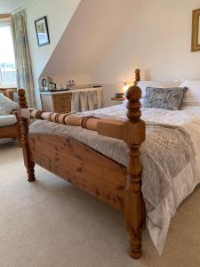 1 dormitorio con cama de madera en una habitación en Dupplin152 bed and breakfast, en Dundee
