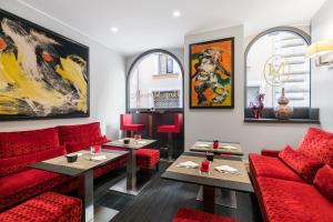 a restaurant with red couches and tables and paintings at Hotel Mancino 12 in Rome