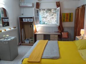 a bedroom with a yellow bed and a desk at Coco Miel in Les Abymes