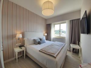 a bedroom with a large bed and a window at Hotel Plaza in Porto Azzurro