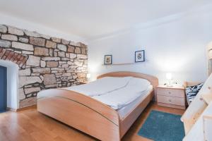 um quarto com uma cama e uma parede de pedra em Apartments Pri Mari em Piran