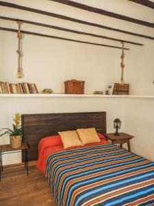 a bedroom with a bed with a colorful striped blanket at La Casa de la Abuela in Villarta de San Juan