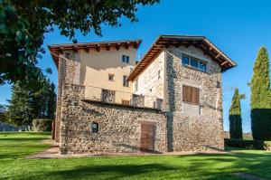un grand bâtiment en pierre avec un balcon sur une pelouse dans l'établissement Antica Residenza Montereano, à Gubbio