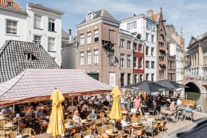 a group of people sitting at tables with umbrellas at Logement Petit Beijers in Utrecht