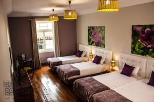 a room with three beds and two lamps at Santa Maria Hostel in Funchal