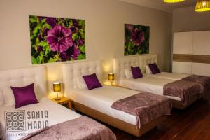 two beds in a hotel room with purple pillows at Santa Maria Hostel in Funchal