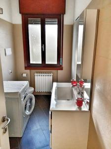a bathroom with a sink and a washing machine at Red Tower Venice - 2 mins from VCE Airport- free Wifi in Tessera