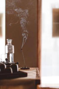 uma garrafa de vidro de fumo ao lado de uma mesa com uma vela em HOY Paris - Yoga Hotel em Paris