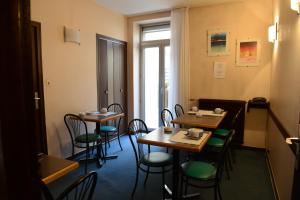 un comedor con mesas y sillas y una ventana en Hôtel du Lion, en Vesoul