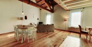 a living room with a table and a dining room at Appartamenti Quota 101 in Arquà Petrarca